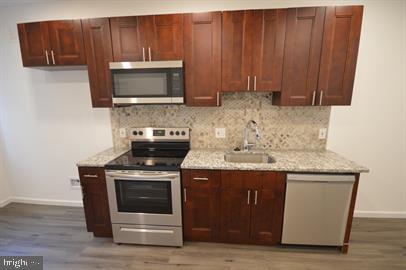 kitchen with stainless steel appliances, dark hardwood / wood-style floors, and sink