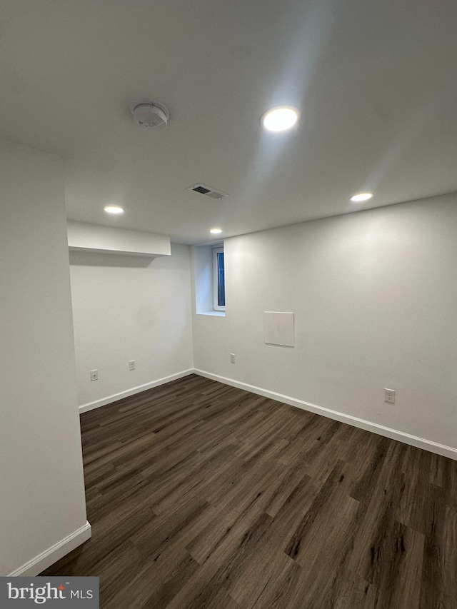 basement with dark hardwood / wood-style floors