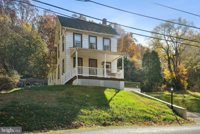 view of front facade with covered porch and a front lawn