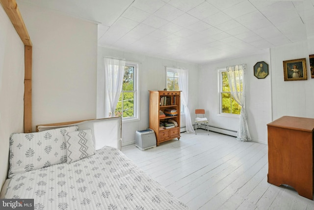 bedroom with light hardwood / wood-style flooring and a baseboard radiator