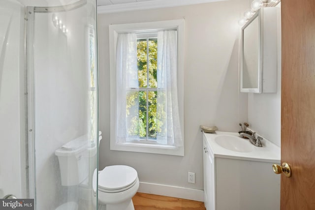 bathroom with toilet, vanity, ornamental molding, and hardwood / wood-style flooring