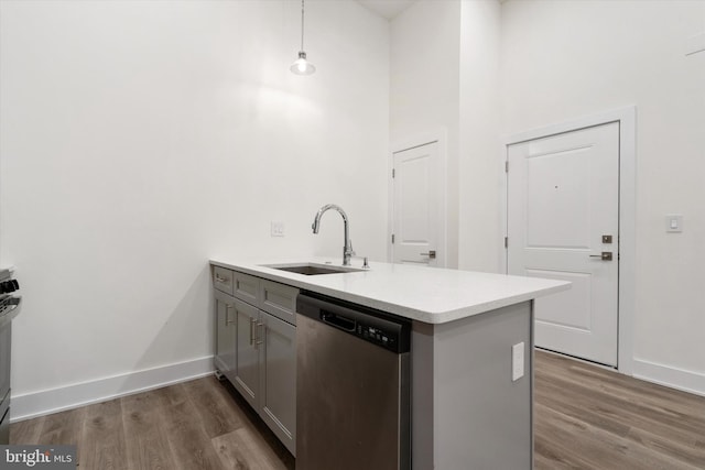 kitchen featuring dark hardwood / wood-style flooring, kitchen peninsula, sink, appliances with stainless steel finishes, and decorative light fixtures