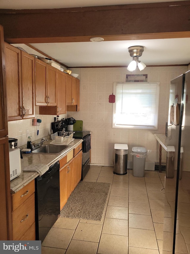 kitchen featuring black appliances, sink, and light tile patterned flooring