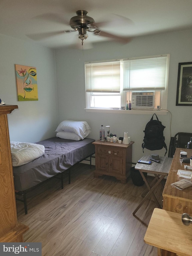 bedroom featuring hardwood / wood-style floors, ceiling fan, and cooling unit