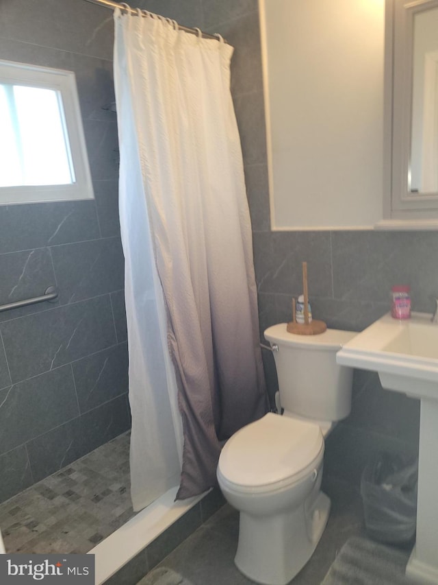 bathroom featuring toilet, tile walls, and curtained shower