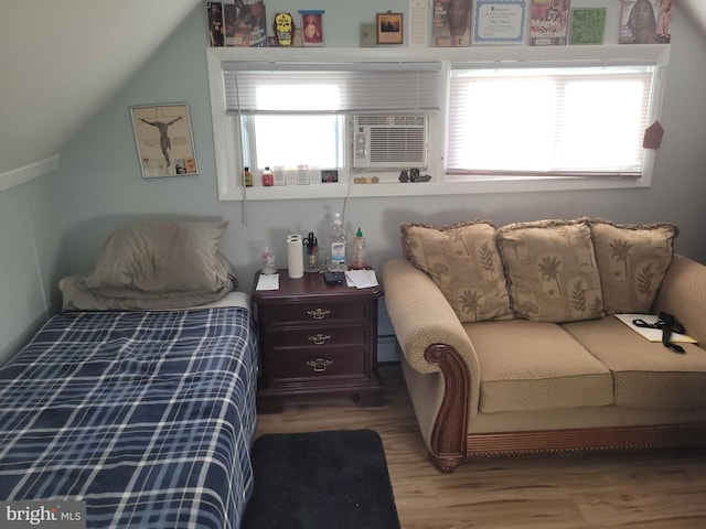 bedroom with hardwood / wood-style floors, cooling unit, and vaulted ceiling