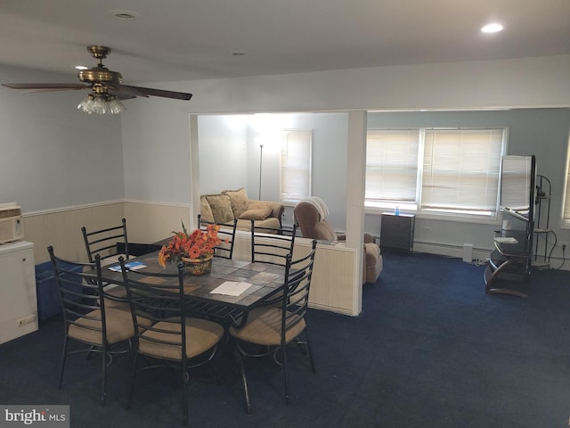 dining space featuring ceiling fan, baseboard heating, and dark carpet