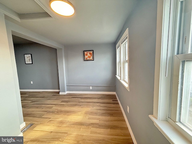 empty room with light hardwood / wood-style floors and plenty of natural light