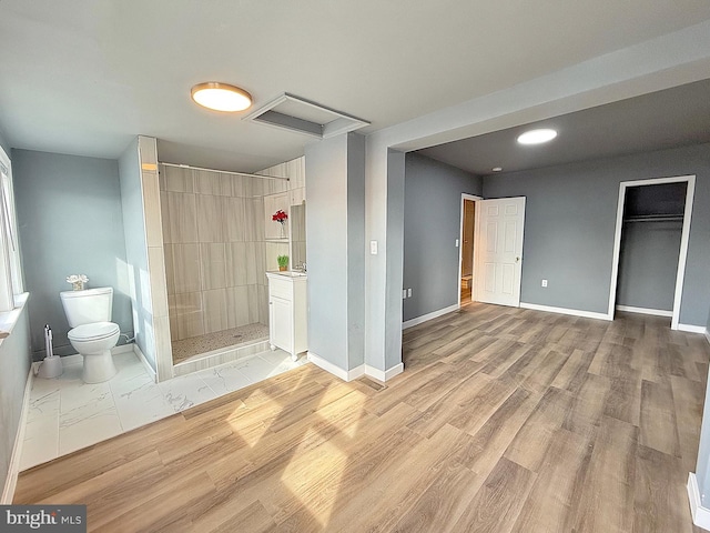 bathroom featuring walk in shower, wood-type flooring, and toilet