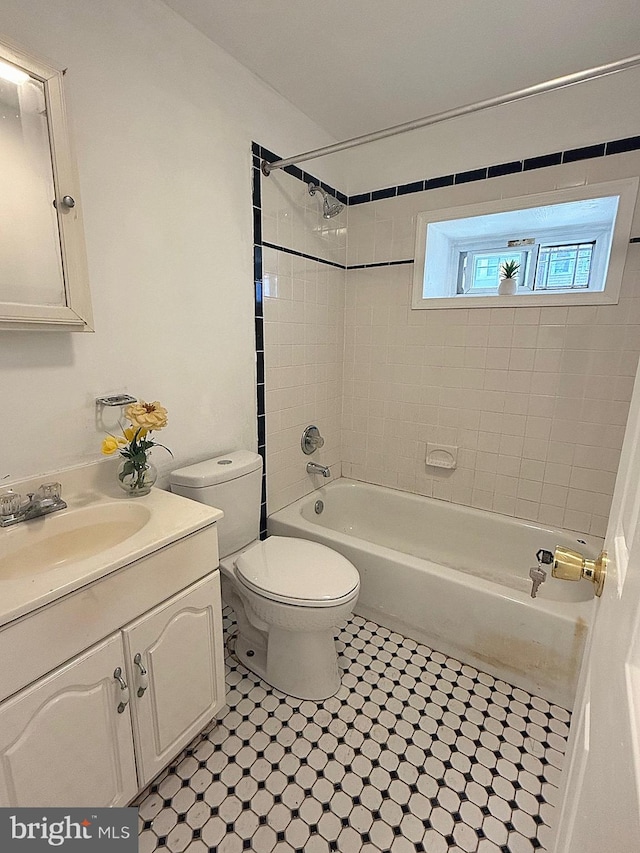 full bathroom with vanity, toilet, and tiled shower / bath combo