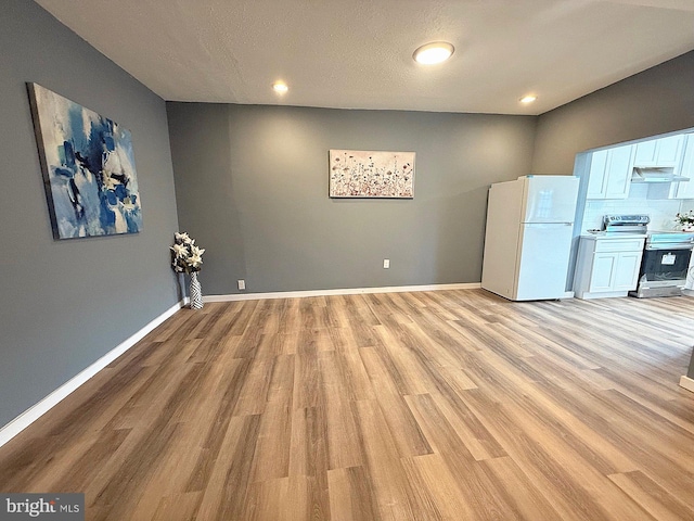 interior space with light wood-type flooring and a textured ceiling