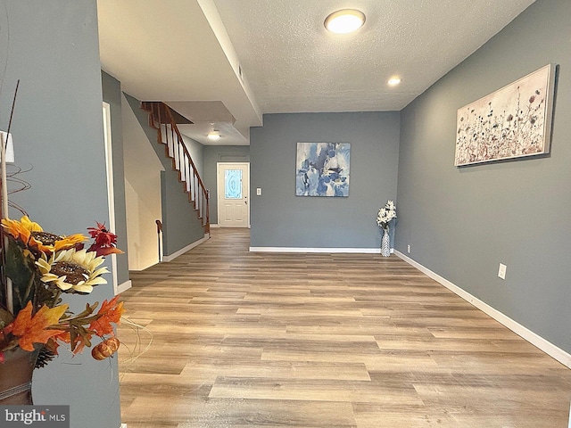 interior space with a textured ceiling and light hardwood / wood-style floors