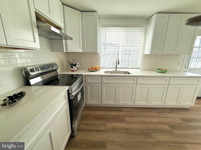 kitchen featuring white cabinets, stainless steel electric range, sink, and light hardwood / wood-style flooring