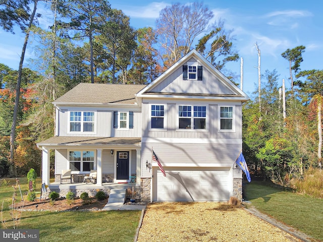 view of front facade featuring covered porch, a garage, and a front yard