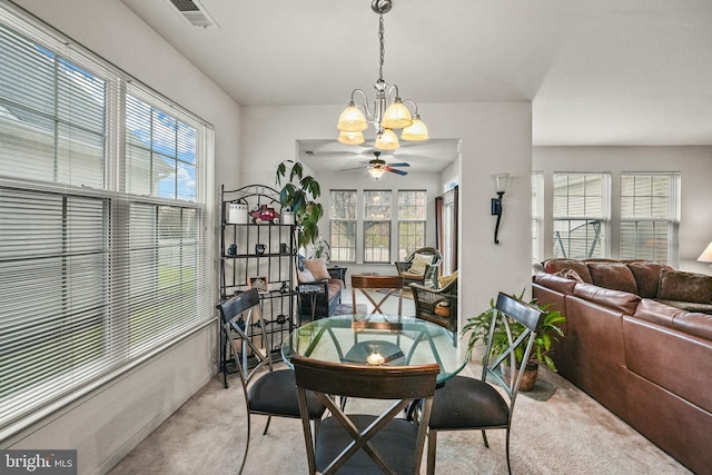 carpeted dining area with plenty of natural light and ceiling fan