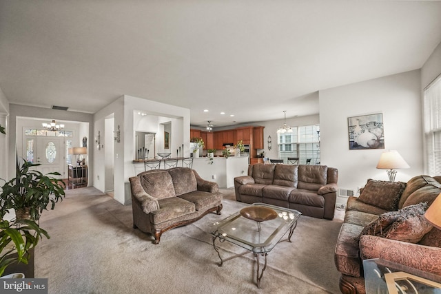 living room with light colored carpet and a notable chandelier