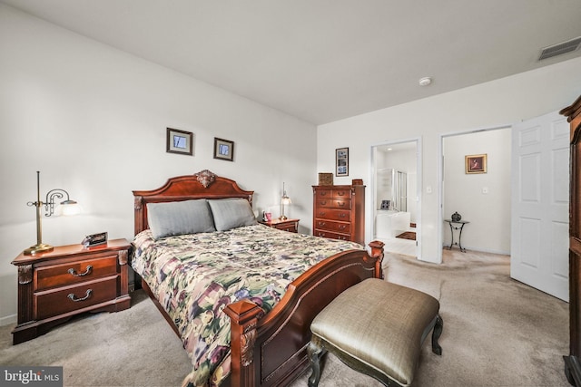 carpeted bedroom featuring ensuite bath