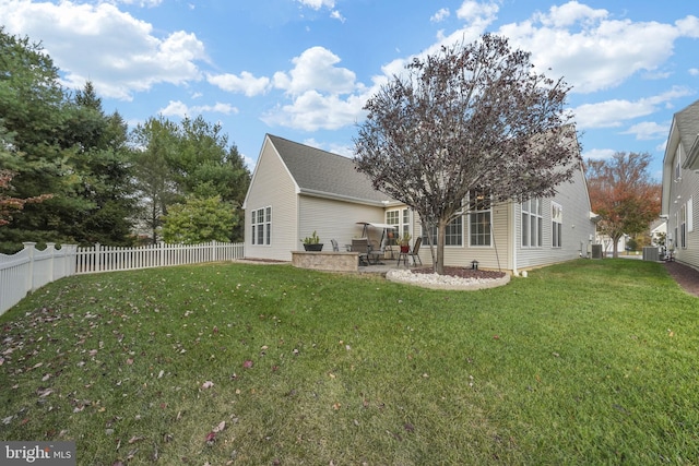 back of property with central air condition unit, a lawn, and a patio