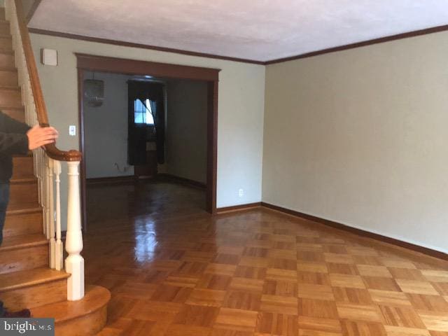 spare room featuring parquet flooring and ornamental molding