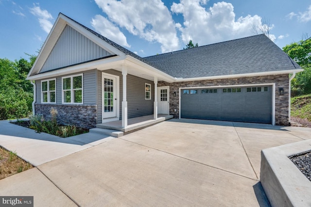 craftsman inspired home featuring a garage and a porch