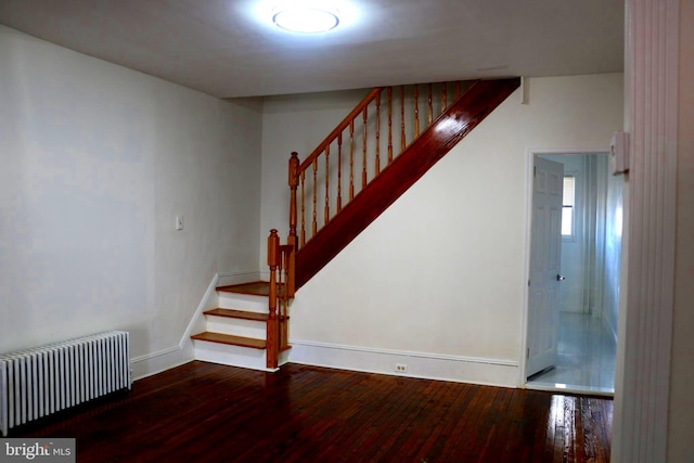 stairway featuring radiator and wood-type flooring