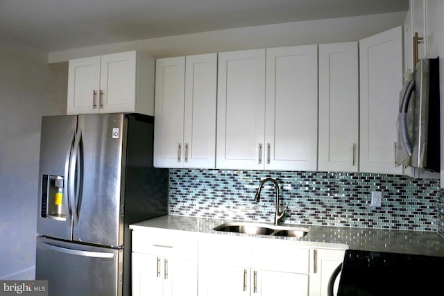 kitchen featuring white cabinets, stainless steel appliances, sink, and backsplash