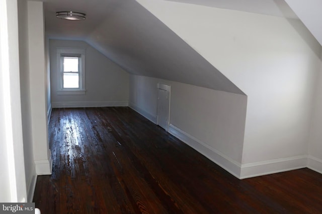 bonus room with dark wood-type flooring and lofted ceiling