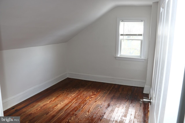 bonus room with dark hardwood / wood-style flooring and vaulted ceiling