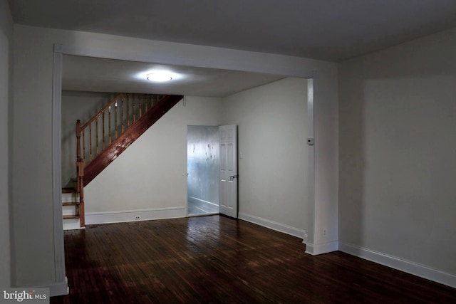 unfurnished room with dark wood-type flooring