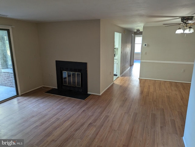 unfurnished living room featuring ceiling fan and light hardwood / wood-style flooring