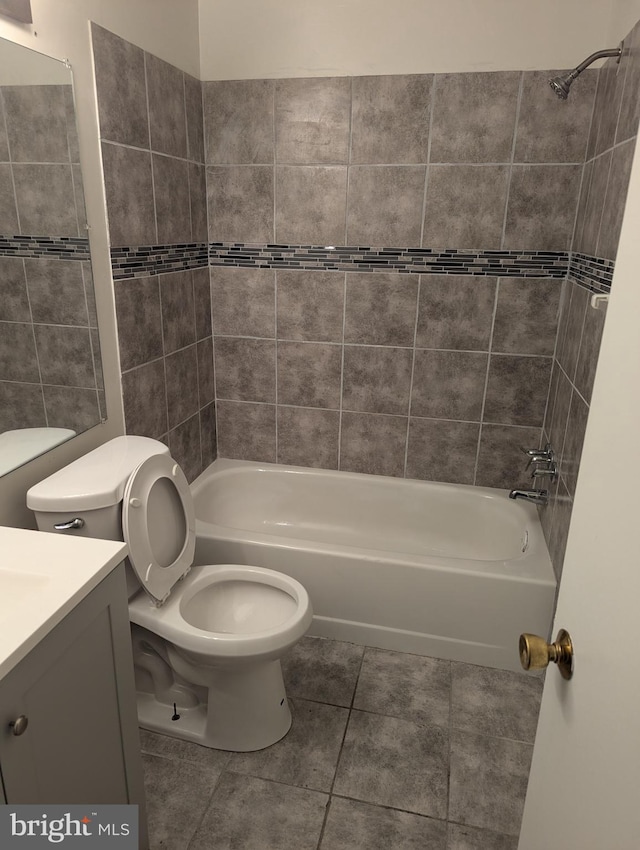 full bathroom featuring tile patterned flooring, vanity, toilet, and tiled shower / bath