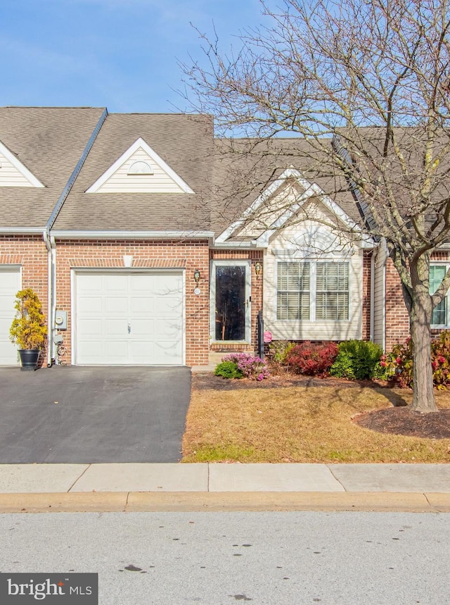 417 E Red Lion Dr, Bear, DE 19701 - townhome / multi-family property with brick siding, a shingled roof, asphalt driveway, a garage, and a front lawn