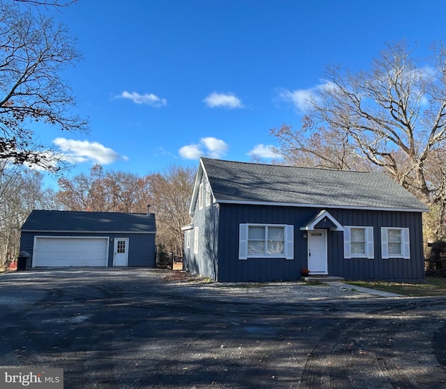 view of front of house with a garage and an outbuilding