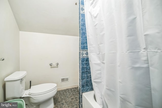 bathroom featuring shower / bath combo with shower curtain and toilet