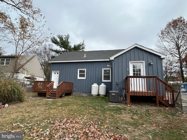 back of property with a lawn and cooling unit