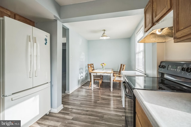 kitchen with dark wood-type flooring, stainless steel range with electric cooktop, and white refrigerator