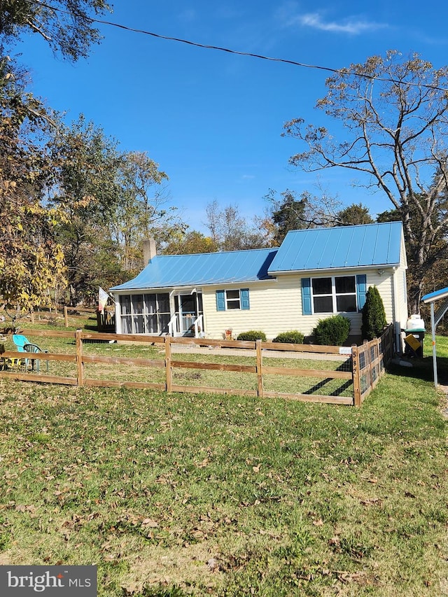 ranch-style house with a sunroom and a front lawn