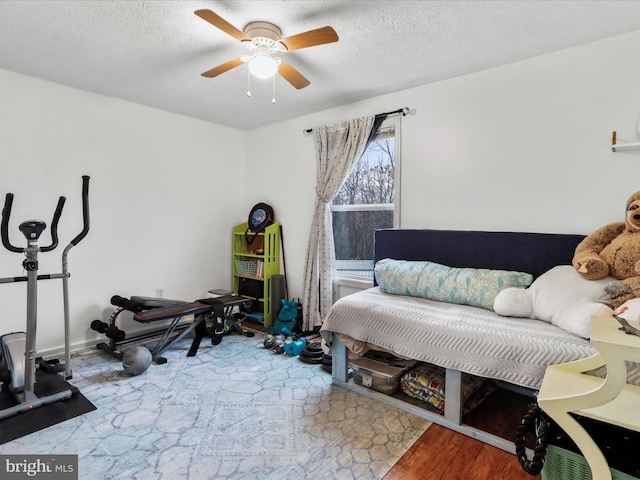 bedroom featuring wood-type flooring, a textured ceiling, and ceiling fan