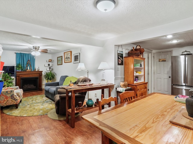 dining area featuring hardwood / wood-style floors, a textured ceiling, and ceiling fan