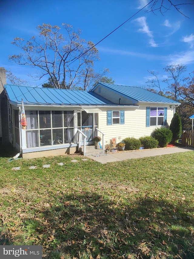 view of front of property with a patio area, a sunroom, and a front yard