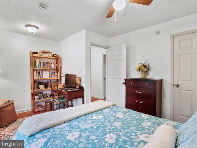 bedroom featuring hardwood / wood-style floors, a textured ceiling, and ceiling fan