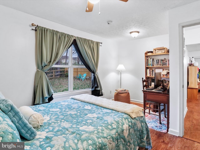 bedroom featuring hardwood / wood-style flooring, ceiling fan, and a textured ceiling