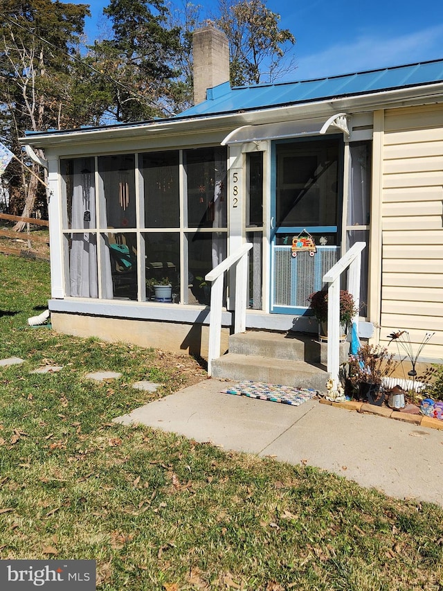 doorway to property with a lawn