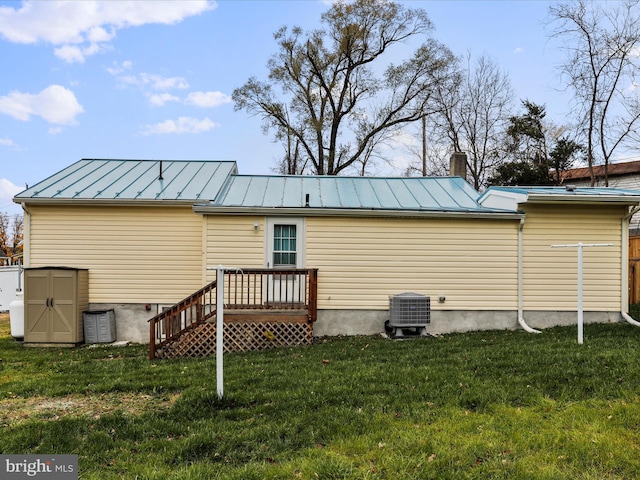 rear view of house with a yard and central air condition unit