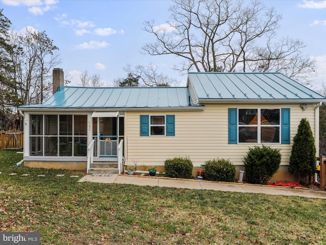 view of front of house with a sunroom and a front yard