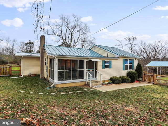 back of property featuring a sunroom and a yard