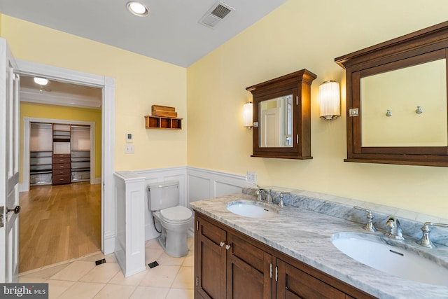 bathroom with toilet, vanity, and tile patterned floors