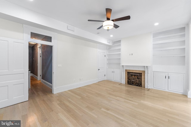 unfurnished living room with light hardwood / wood-style flooring, ceiling fan, and built in features