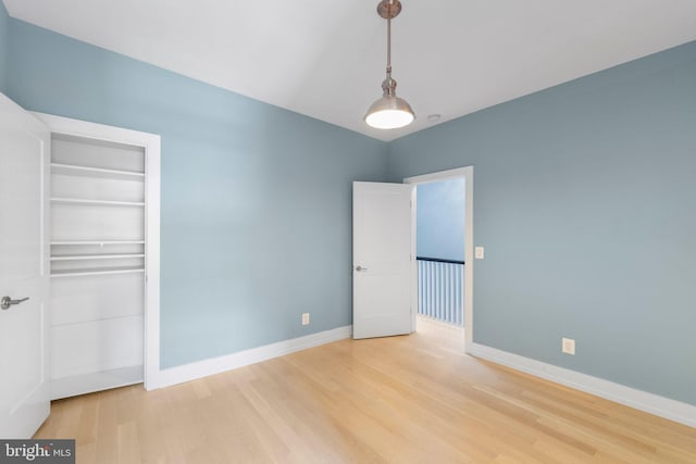 unfurnished bedroom featuring a closet and hardwood / wood-style flooring