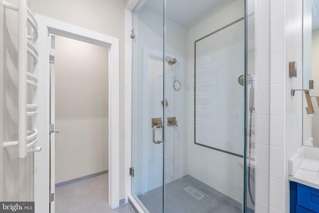 bathroom featuring vanity, tile patterned flooring, and a shower with shower door